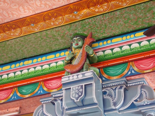 Agamis playing instruments on a pillar in the hall
